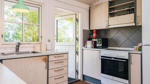 A modern kitchen with a large island, built-in appliances, and a view of the outdoors. - 8 Person Holiday Home in Knebel-by Traum (Knebel)