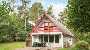 A small, single-story house with a red roof and white walls, surrounded by a grassy yard and trees. - 5 Person Holiday Home in Ebeltoft (Ebeltoft)