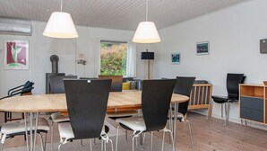Un comedor moderno con una mesa de madera y sillas negras, un sofá y una lámpara.