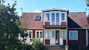 A two-story house with a front porch, a small garden, and a red and white color scheme. - Holiday Home in Sölvesborg (Sölvesborg)