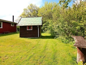 Escape to a serene cabin nestled among lush greenery, featuring a cozy window seat and a peaceful atmosphere.