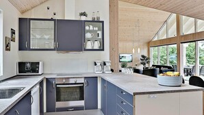 A modern kitchen with a built-in oven, microwave, and coffee maker. - Pet Friendly Holiday Home in Dronningmølle near Sea (Dronningmolle)