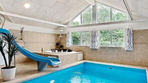 An indoor swimming pool with a blue slide, a bathtub, and a shower. - Pet Friendly Holiday Home in Dronningmølle near Sea (Dronningmolle)
