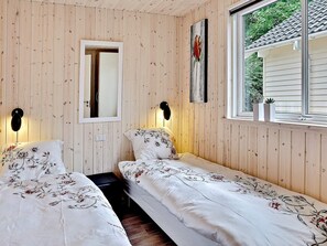 A room with two beds, a mirror, and a window with a view of greenery. - Pet Friendly Holiday Home in Dronningmølle near Sea (Dronningmolle)