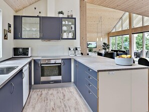 A modern kitchen with a built-in oven, microwave, and coffee maker. - Pet Friendly Holiday Home in Dronningmølle near Sea (Dronningmolle)