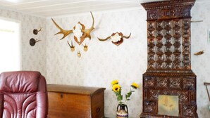 Ein Zimmer mit Ledersessel, Holzschrank, dekorativem Kamin und Wanddekoration aus Geweihen.