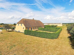 A large house with a tiled roof and a well-maintained garden.