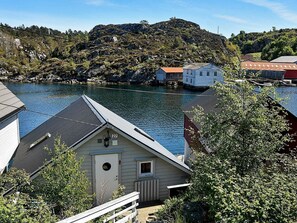 A coastal house with a view of the sea and hills in the background. - Holiday Home in Urangsvåg (Bomlo)