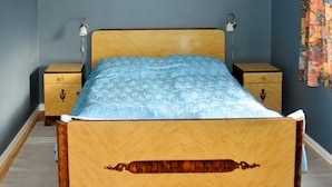 A bed with a wooden headboard, two bedside tables, and a patterned bedspread. - 8 Person Holiday Home in Afarnes (Rauma)