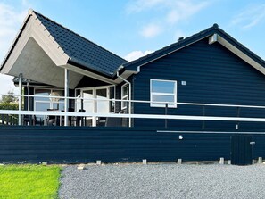 A two-story building with a covered porch and a small window. - 4 Star Holiday Home in Roslev (Roslev)