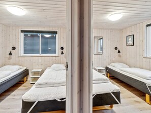 A room with two beds, a window, and a mirror. - 5 Star Holiday Home in Vejby (Vejby)