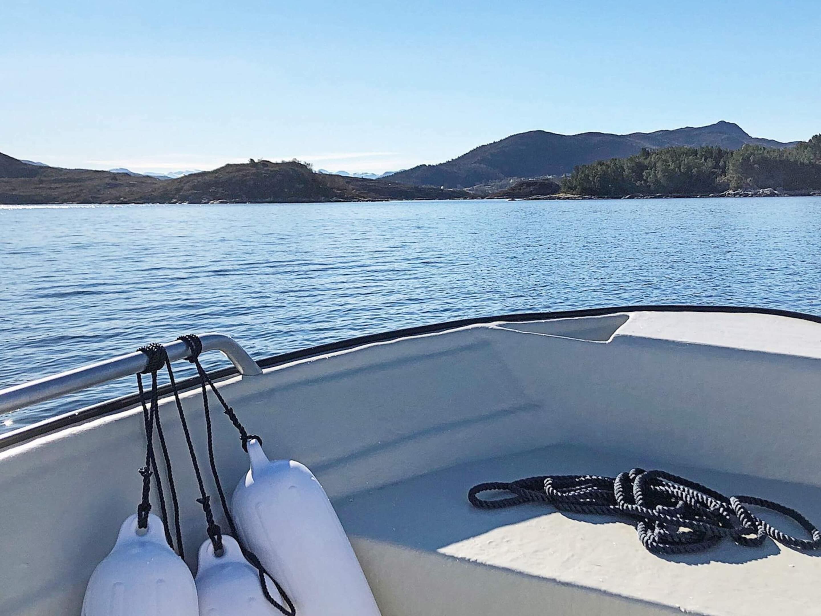 A boat's interior with a view of calm water and distant hills.