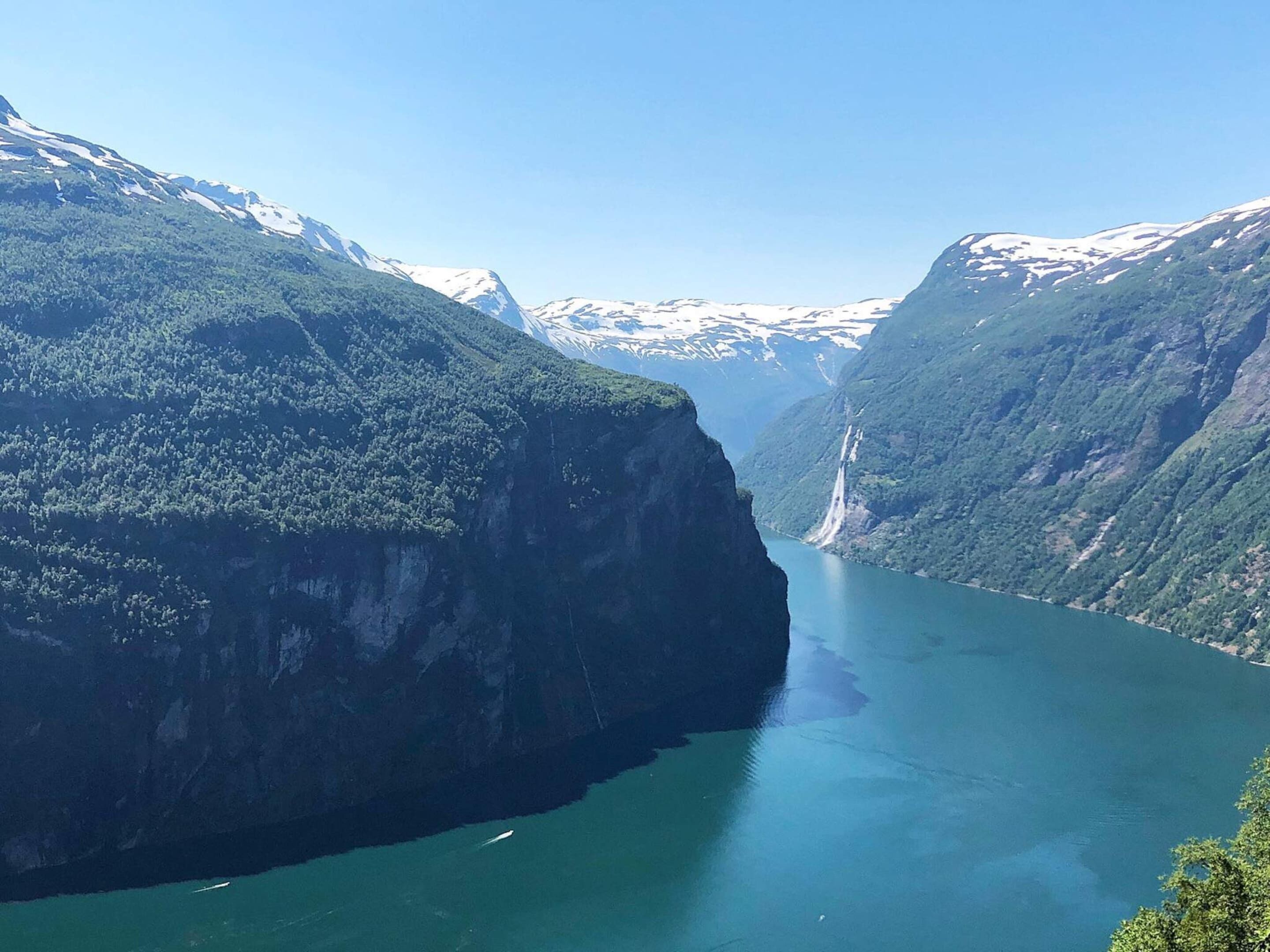 A fjord with steep cliffs and a waterfall.
