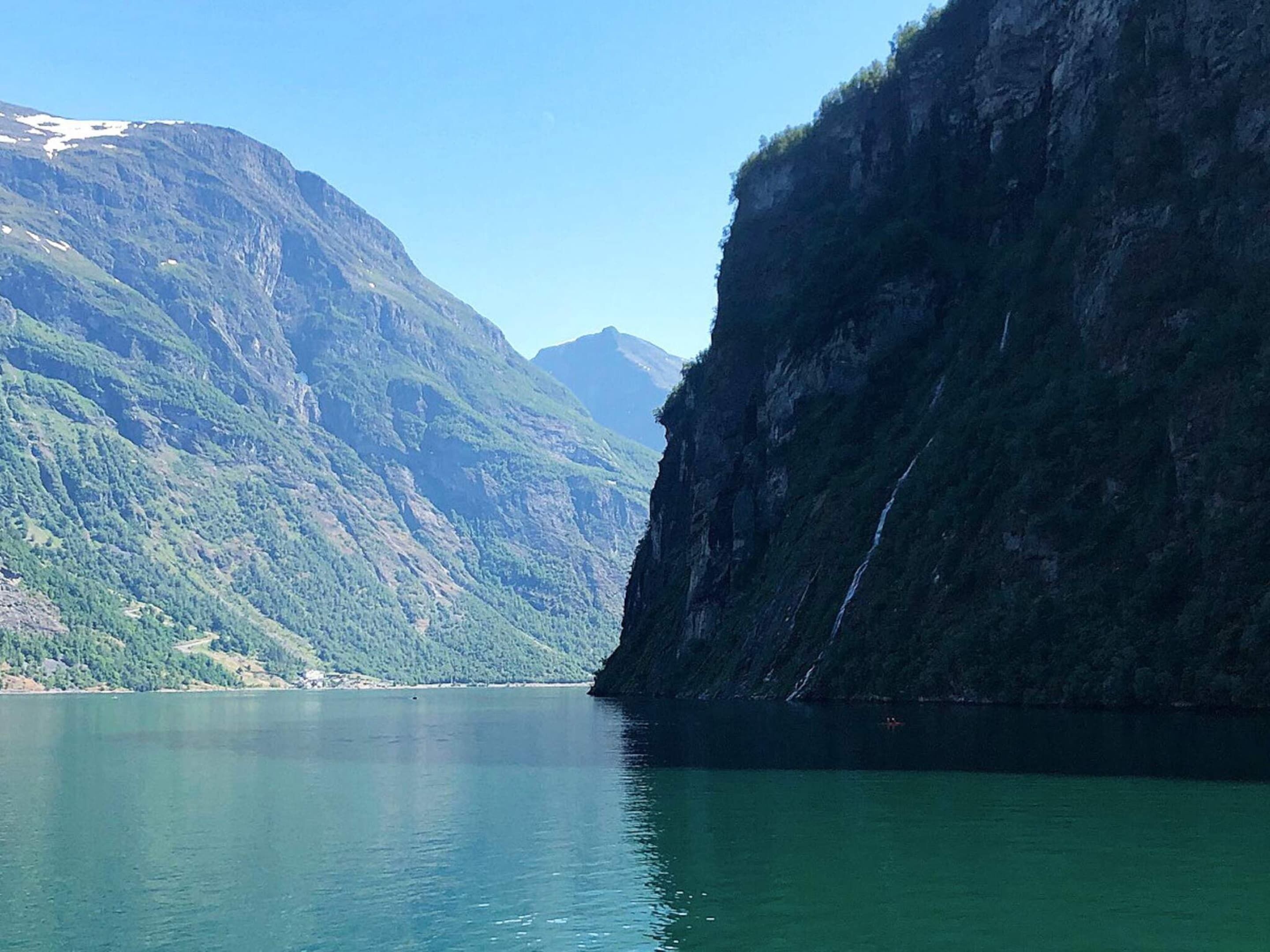 A serene lake surrounded by steep, forested mountains.