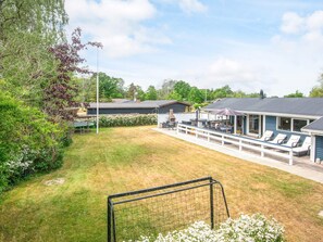 A residential property with a covered patio, outdoor seating, and a fenced yard. - 4 Star Holiday Home in Glesborg (Glesborg)
