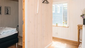A room with a bed, a window with a view, a hanging light fixture, and a wall-mounted heater. - 4 Star Holiday Home in Glesborg (Glesborg)