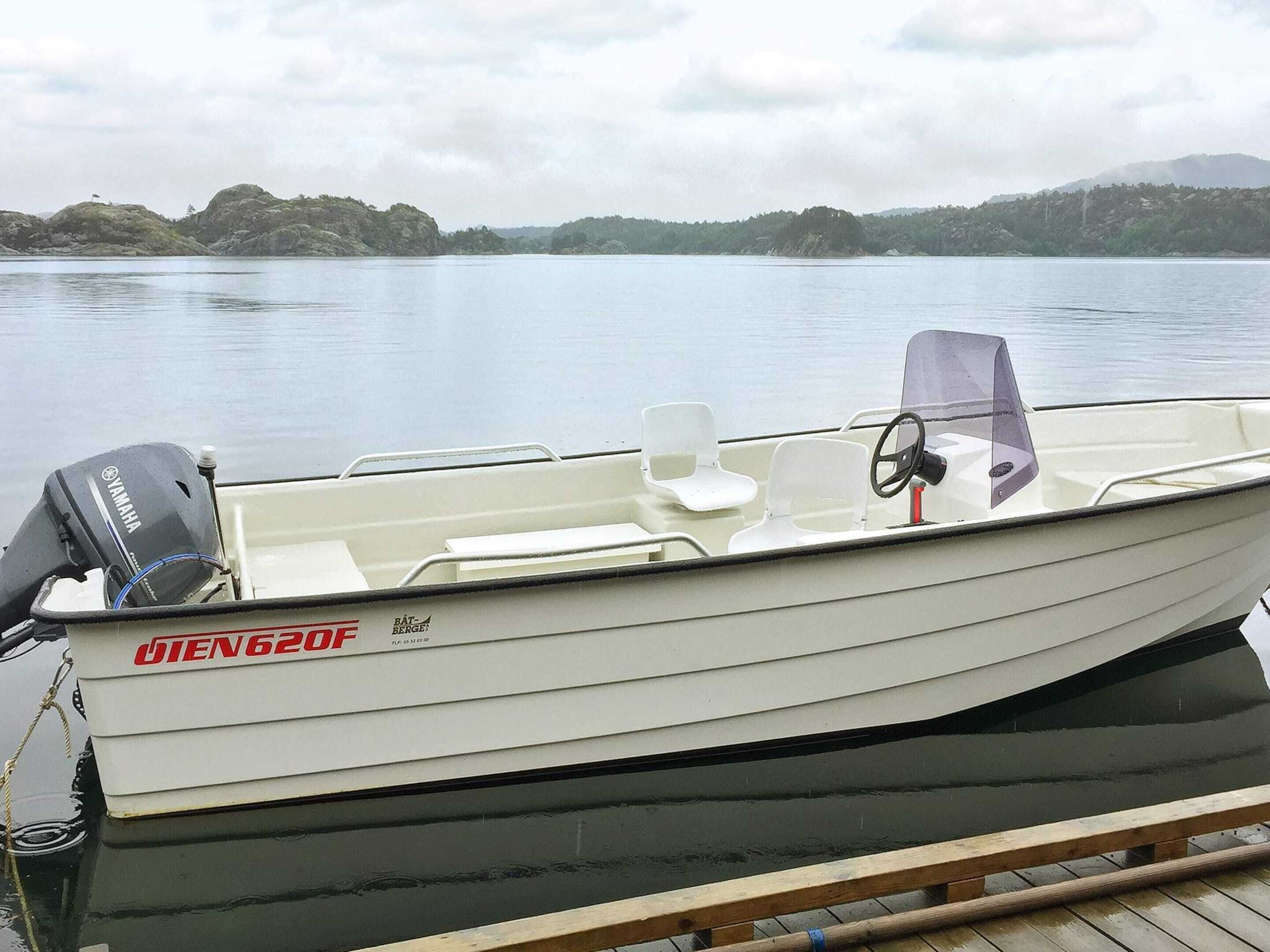 Ein kleines Motorboot mit einem Yamaha Außenborder, mit dem Aufdruck 'BIEN 620F', liegt an einem hölzernen Steg.