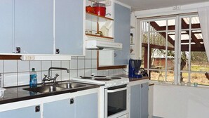 Una cocina compacta con lavamanos, estufa y armarios.
