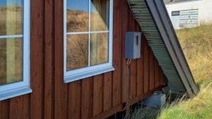 A wooden building with a window and a metal roof.