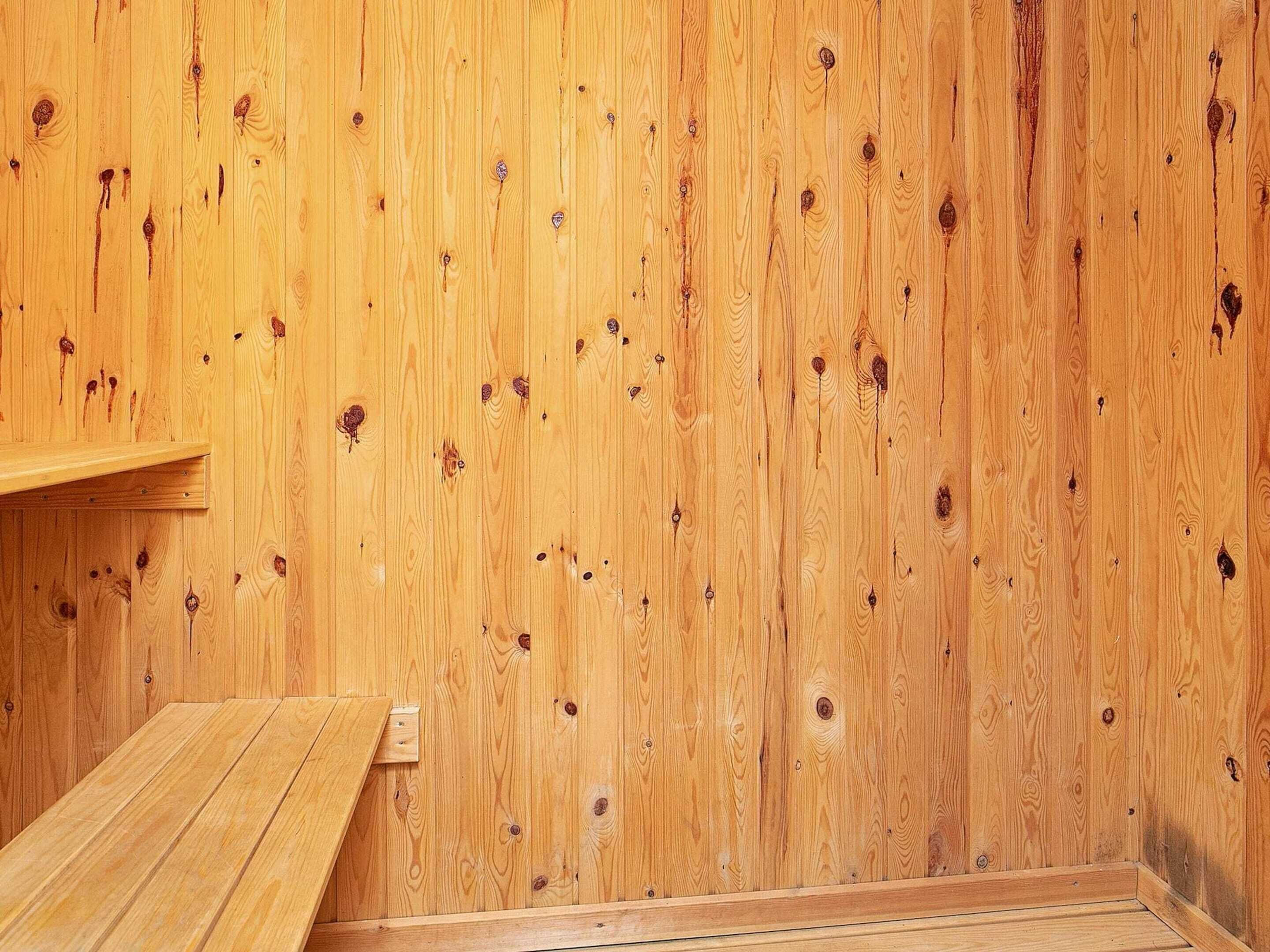 A room with wooden walls and a wooden bench.