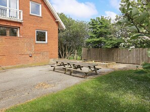 A brick house with a wooden deck, picnic table, and a fenced garden area. - 40 Person Holiday Home in Hurup Thy (Hurup Thy)