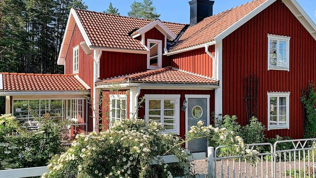 A red wooden house with a tiled roof, white trim, and a chimney. - Holiday Home in Gedser (Gamleby)