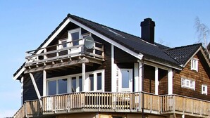 A two-story wooden house with a balcony, a satellite dish, and a chimney. - 10 Person Holiday Home in Bygstad (Sunnfjord)