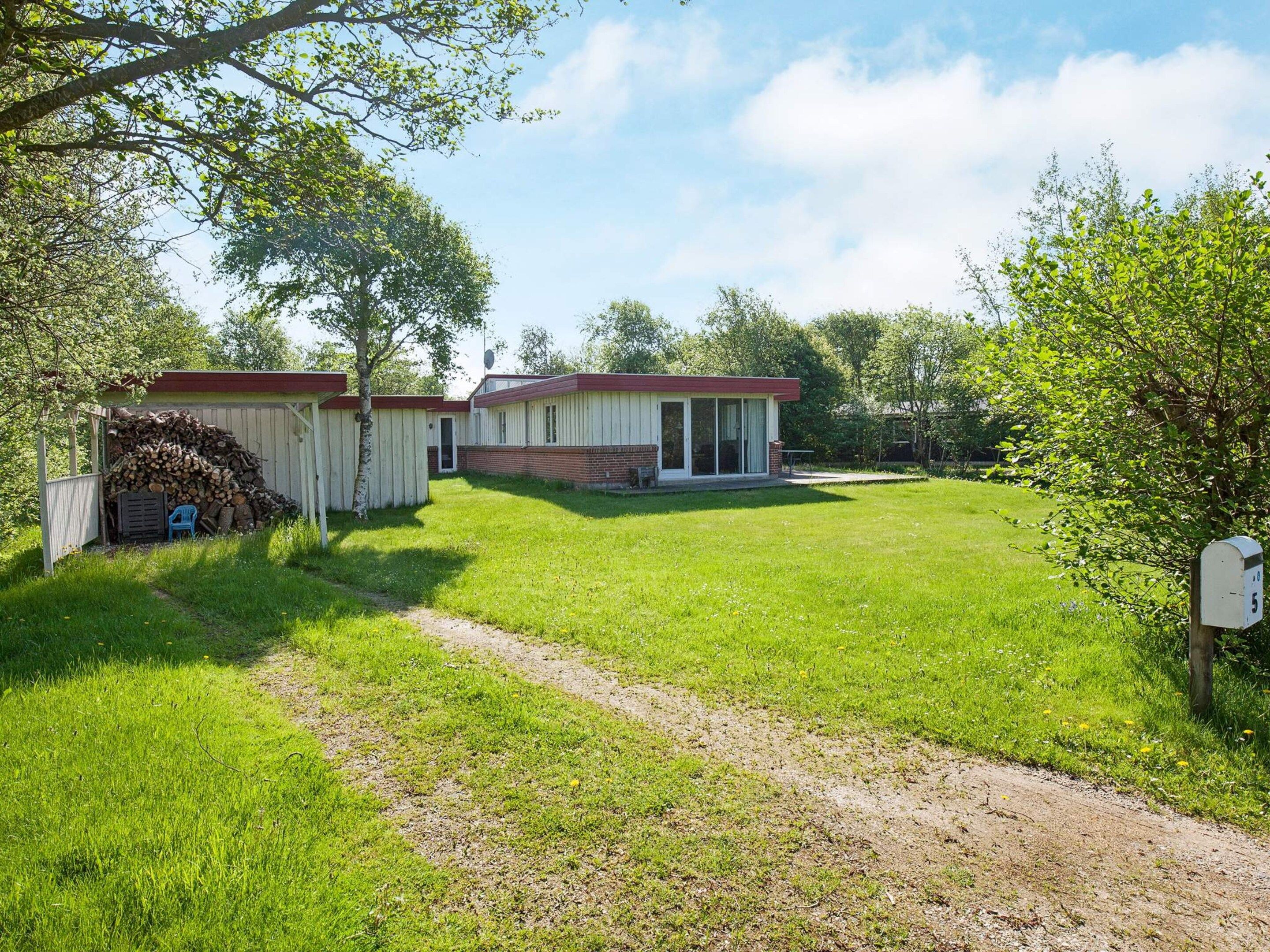 Ein Wohnhaus mit gepflegtem Rasen, Holzumzäunung und einer separaten Garage.