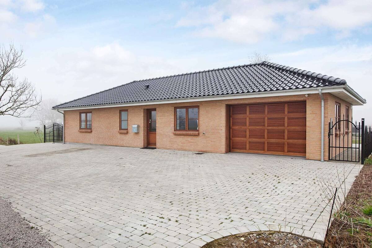A single-story brick building with a tiled roof, a front garage, and a paved driveway.