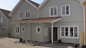 A two-story house with a covered porch, a tiled roof, and a stone pathway leading to the entrance. - Holiday Home in Skärhamn (Skaerhamn)