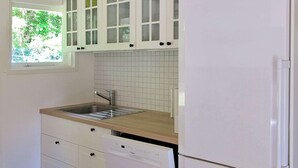 A kitchen with white cabinets, a stainless steel sink, and a built-in dishwasher. - Tranquil Holiday Home in Hals near Beach (Hals)