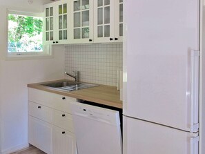 A kitchen with white cabinets, a stainless steel sink, and a built-in dishwasher. - Tranquil Holiday Home in Hals near Beach (Hals)