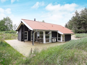 A house with a red-tiled roof, a covered porch, and a wooden deck. - Quaint Holiday Home in Skagen near Sea (Skagen)