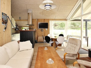 A cozy living room with a sofa, a wooden coffee table, and a television. - Quaint Holiday Home in Skagen near Sea (Skagen)