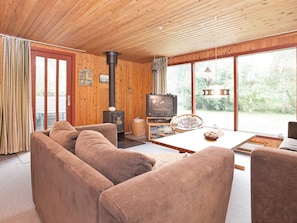 A cozy living room with a sofa, television, and a fireplace.