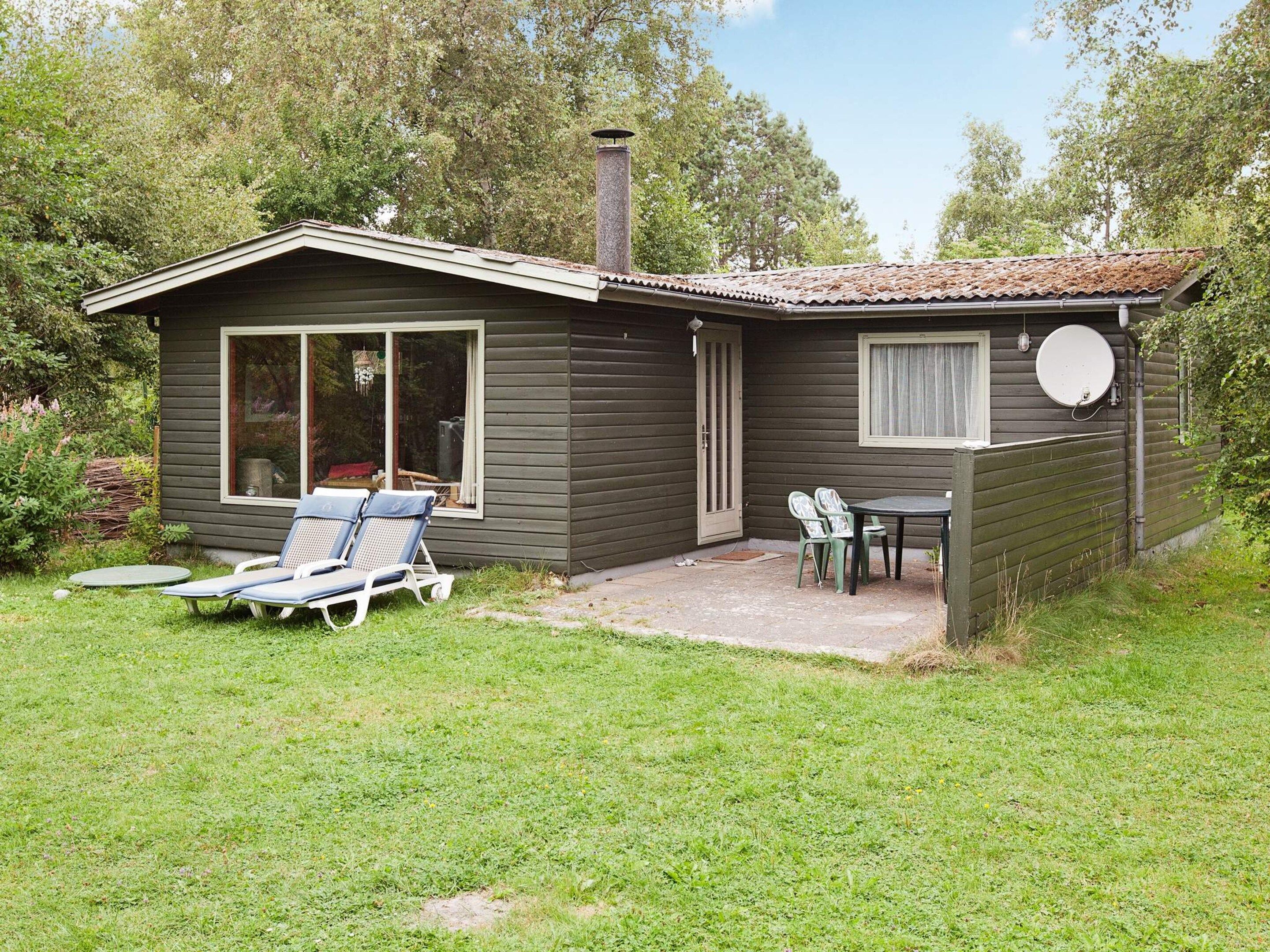 A small house with a patio, a sliding glass door, and a satellite dish.