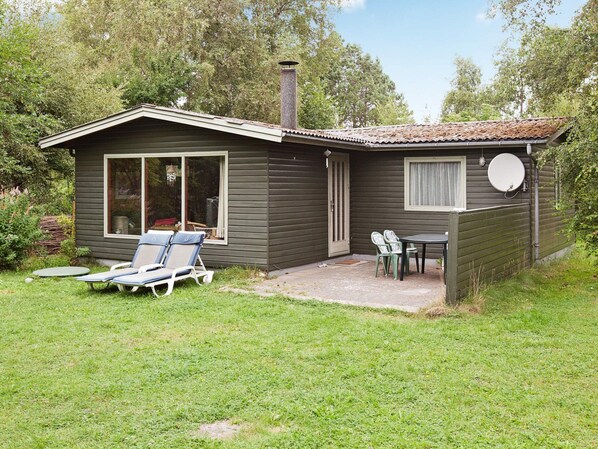 A small house with a patio, a sliding glass door, and a satellite dish.