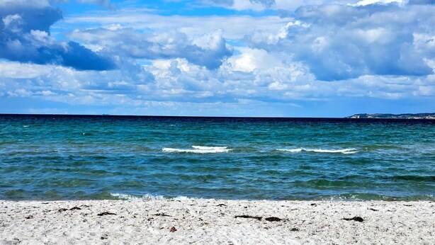 A beach with clear blue water and a sandy shore. - 4 Star Holiday Home in Ebeltoft (Ebeltoft)