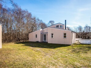 A single-story building with a gabled roof, a chimney, and a small porch area. - 4 Star Holiday Home in Ebeltoft (Ebeltoft)