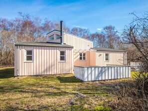 A two-story house with a chimney, a fenced yard, and a clear sky. - 4 Star Holiday Home in Ebeltoft (Ebeltoft)