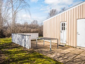 A building with a door and a window, a table, and a fenced area. - 4 Star Holiday Home in Ebeltoft (Ebeltoft)