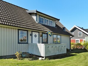 A two-story house with a tiled roof, a visible number '8' on the door, and a flag. - Holiday Home in Lysekil (Lysekil)