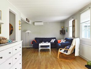 A living room with a sofa, a chair, a coffee table, and a dresser. - Holiday Home in Lysekil (Lysekil)