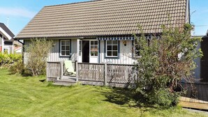 A single-story house with a tiled roof, a front porch, and a wooden fence. - Holiday Home in Lysekil (Lysekil)