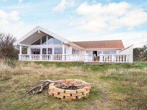 A large white house with a covered porch and a fire pit in the foreground. - Pet-friendly Holiday Home in Sjællands Odde near Sea (Sjællands Odde)