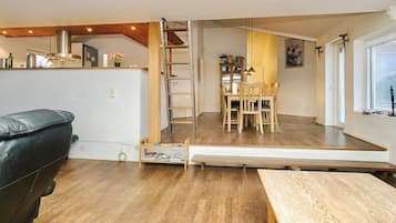A compact living space with a dining area, a sofa, and a wooden table.