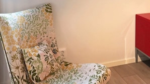 A corner of a room with a floral-patterned chair and a red table. - 4 Star Holiday Home in Akersberga (Akersberga)