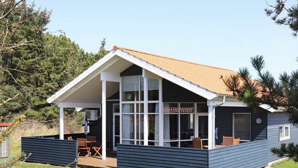 A two-story house with a covered porch, large windows, and a tiled roof. - 4 Star Holiday Home in Ulfborg (Ulfborg)