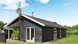 A modern house with a sloped roof, satellite dish, and chimney.