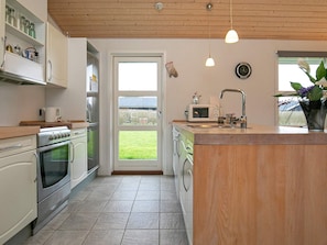 A modern kitchen with a built-in oven, microwave, and sink.